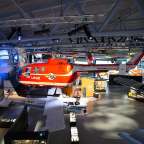 Ein rot-weißer Hubschrauber mit der Aufschrift lege hängt in einem Museum
