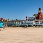 Ein blauer Rettungsturm steht am Strand vor einem großen Hotel