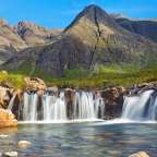 Ein Wasserfall in einem Tal mit Bergen im Hintergrund