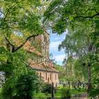 Eine Kirche umgeben von Bäumen und einem Friedhof