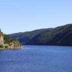 Ein großer blauer See umgeben von Bergen und Bäumen