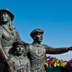Eine Statue einer Frau und zwei Jungen mit Blumen im Hintergrund