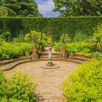 Ein kreisförmiger Garten mit einem Brunnen in der Mitte