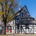 Eine weiße und schwarze Kirche mit einem runden Turm
