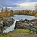Ein Wasserfall in einem Fluss mit Bäumen im Hintergrund