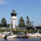 Ein schwarz-weißer Leuchtturm steht über einem See