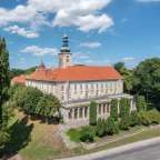 Ein großes Gebäude mit einem roten Dach und einem Turm darauf