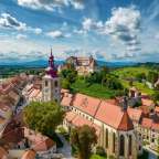 Eine Stadt mit einer Kirche und einem Schloss auf einem Hügel