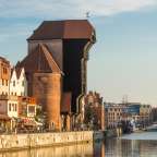 Eine Reihe von Gebäuden neben einem Fluss mit einem Turm darauf