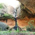 Ein Wasserfall stürzt aus einer Felswand in eine Höhle