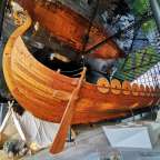 Ein großes Holzboot steht in einem Museum