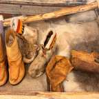 Ein paar braune stiefel sitzen auf einem pelzbedeckten boden
