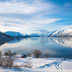 Ein schneebedeckter See mit Bergen im Hintergrund