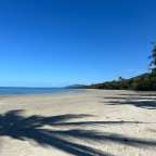 Ein Strand mit Palmen und Bergen im Hintergrund