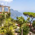 Ein Garten mit Palmen und Blumen mit Blick auf den Ozean