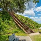 Eine Holztreppe führt auf einen Hügel hinunter