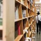 Ein Mann geht in einem Buchladen und schaut sich die Bücher an