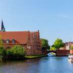 Ein kleines rot-weißes Boot fährt durch einen Fluss
