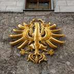 Ein goldenes Wappen an der Seite eines Gebäudes
