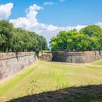 Ein großes grünes Feld neben einer Ziegelmauer