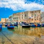 Ein Hafen mit vielen Booten und Gebäuden im Hintergrund