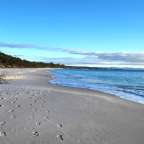 Ein Strand mit Füßenspuren im Sand