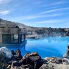 Ein kleines Haus steht in der Mitte eines großen blauen Pools .