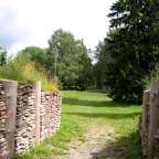 Ein bewaldetes Gelände in Estland mit restaurierten Steinmauern und Holzbalken der historischen Burg Varbola.