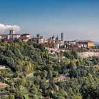 Eine Stadt liegt auf einem Hügel mit Bäumen umgeben