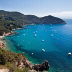 Eine Bucht mit vielen Booten und Bergen im Hintergrund