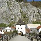 Eine Holzbrücke führt zu einem weißen Gebäude