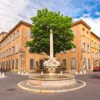 Ein Brunnen steht in der Mitte einer Straße neben einem Baum
