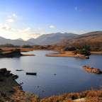 Ein See mit kleinen Inseln und Bergen im Hintergrund