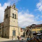 Eine Gruppe von Menschen steht vor einer Kirche mit einem Uhrturm