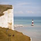 Eine Gruppe von Menschen steht auf einer Klippe mit Blick auf das Meer
