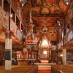 Ein sehr langes Kirchenschiff mit vielen Gemälden an den Wänden
