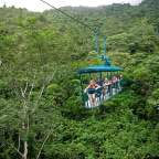 Eine Gruppe von Menschen fährt auf einer Seilbahn durch den Dschungel