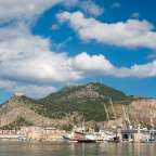 Ein Hafen mit vielen Kränen und einem Berg im Hintergrund