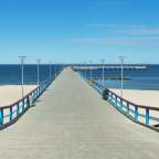 Eine lange Holzbrücke führt zum Meer