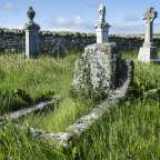 Ein Friedhof mit Grabsteinen und Kreuzen und einer Steinmauer
