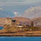 Eine Burg auf einem Felsen mit Bergen im Hintergrund