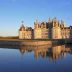 Ein großes Schloss spiegelt sich im Wasser