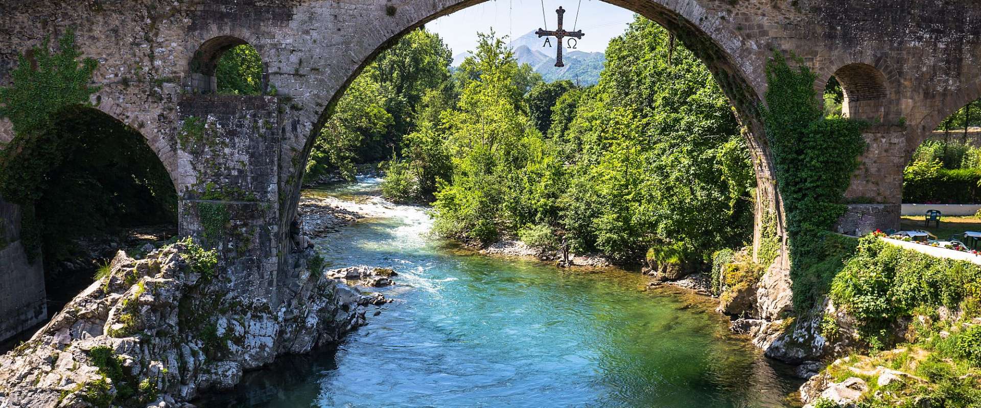 Eine Brücke über einen Fluss mit einem Kreuz darauf