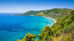 Ein Blick auf einen Strand mit Bergen im Hintergrund