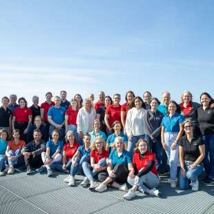 Eine Gruppe von Menschen posiert für ein Foto auf einem Dach