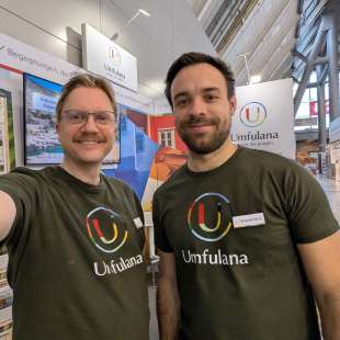 Zwei Männer stehen nebeneinander und tragen umfulana-Shirts