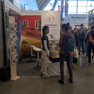 Eine Frau steht vor einem Stand mit einem Schild, das liest limfulana