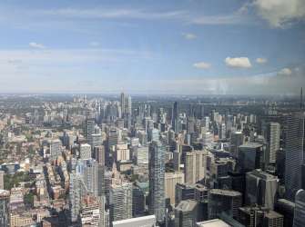 Blick von oben auf die Skyline von Toronto mit zahlreichen Wolkenkratzern und Gebäuden am hellen Tag.