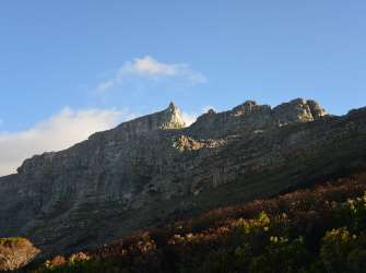 Nachmittagssonne beleuchtet den Tafelberg mit Maclear’s Beacon und den Hangehängen in Kapstadt.