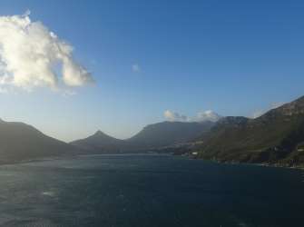 Blick auf Hout Bay und die umliegenden Berge auf der Kap-Halbinsel an einem sonnigen Tag.